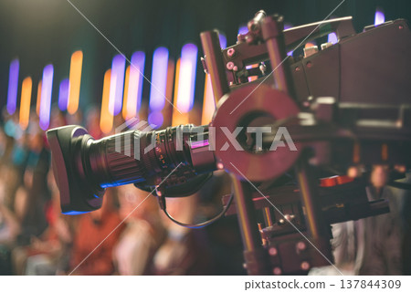 Professional broadcast video camera filming live event with neon lights and copy space 137844309