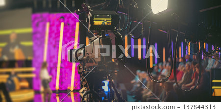 Professional broadcast camera in modern TV studio with neon lights and copy space Professional broadcast camera in modern TV studio with neon lights and copy space 137844313