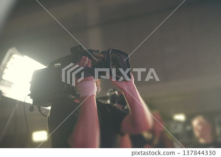 Cameraman filming press conference in news studio with copy space 137844330