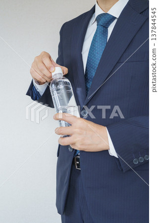 A businessman holding a water bottle A businessman holding a water bottle 137844545