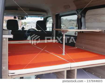 A fully flat interior space created by customizing a minivan for overnight stays in the car. 137844603
