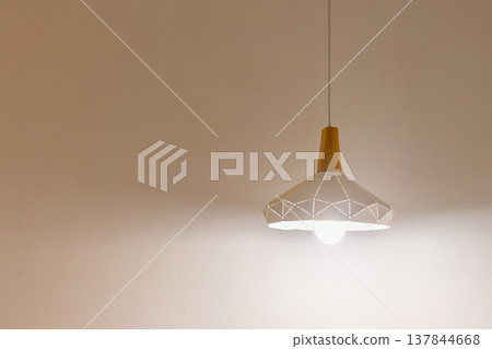 Hanging lamp from the ceiling that lights up the room. Copy space background texture Hanging lamp from the ceiling that lights up the room. Copy space background texture 137844668