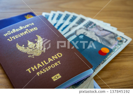 National passport and Thai Airways airline ticket on wooden background for international travel, tourism and business. National passport and Thai Airways airline ticket on wooden background for international travel, tourism and business. 137845192