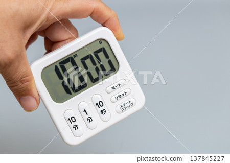 我手裡拿著一個設定為10分鐘的廚房計時器。 我手裡拿著一個設定為10分鐘的廚房計時器。 137845227