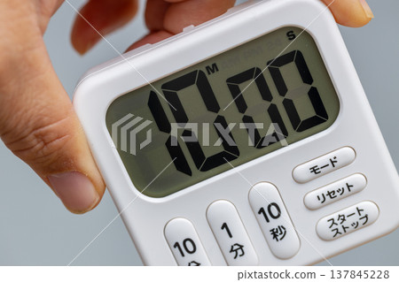我手裡拿著一個設定為10分鐘的廚房計時器。 我手裡拿著一個設定為10分鐘的廚房計時器。 137845228