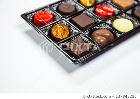 Chocolates in various shapes in beautiful premium packaging boxes on white background. Copy space background Chocolates in various shapes in beautiful premium packaging boxes on white background. Copy space background 137845283