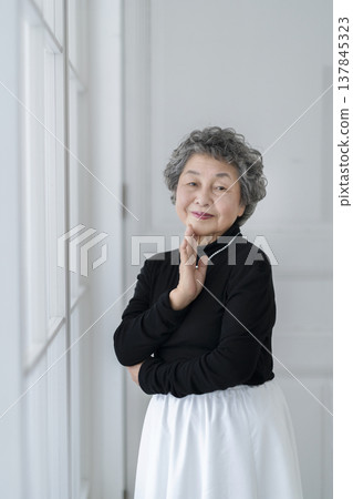 一位優雅的老婦人面帶微笑地看著鏡頭。 137845323