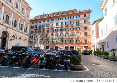 Cars and motorcycles are parked in a square in Rome on a sunny day with clear skies Cars and motorcycles are parked in a square in Rome on a sunny day with clear skies 137845401