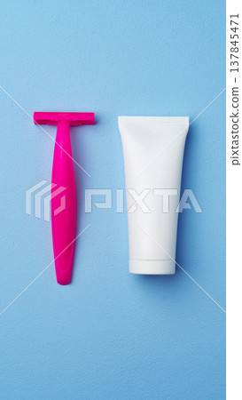 Razor and cream placed side by side on a blue surface for grooming purposes Razor and cream placed side by side on a blue surface for grooming purposes 137845471