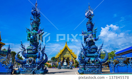 Pole carve of art fairy tale at Wat Rong Sua Ten temple with blue sky background, Chiang Rai Province, Thailand, It's a popular destination and Landmark of Chiang Rai Pole carve of art fairy tale at Wat Rong Sua Ten temple with blue sky background, Chiang Rai Province, Thailand, It's a popular destination and Landmark of Chiang Rai 137845578
