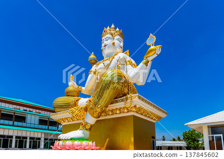 Big statue of god in Hinduism or Great Brahma sit on the base with sky background at Wat Saman Rattanaram temple in Chachoengsao province Thailand. 137845602