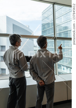 商人們在現場開會，同時查看藍圖。 137845612