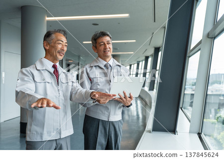 一名工地主管和一名資深人員正在現場查看藍圖。 137845624