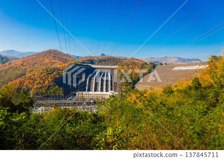 Srinakarin Dam the power station with large mountains and many trees at Kanchanaburi, Thailand. To generate electricity in the western region of the country Srinakarin Dam the power station with large mountains and many trees at Kanchanaburi, Thailand. To generate electricity in the western region of the country 137845711