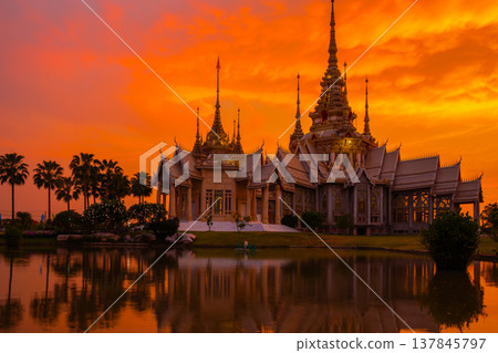The beautiful golden buddhist temple with water reflect shadow in sunset time at Nakhon Ratchasima Thailand The beautiful golden buddhist temple with water reflect shadow in sunset time at Nakhon Ratchasima Thailand 137845797