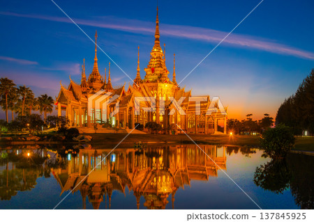 The beautiful golden buddhist temple with water reflect shadow in sunset time at Nakhon Ratchasima Thailand The beautiful golden buddhist temple with water reflect shadow in sunset time at Nakhon Ratchasima Thailand 137845925