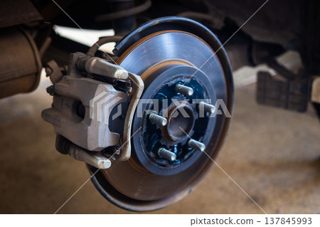 The car's wheels were removed, exposing the discs and disc brakes for tire changes and repairs. 137845993