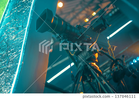 Professional Broadcasting Camera on Tripod in Cinematic Teal and Orange Lighting with copy space Professional Broadcasting Camera on Tripod in Cinematic Teal and Orange Lighting with copy space 137846111