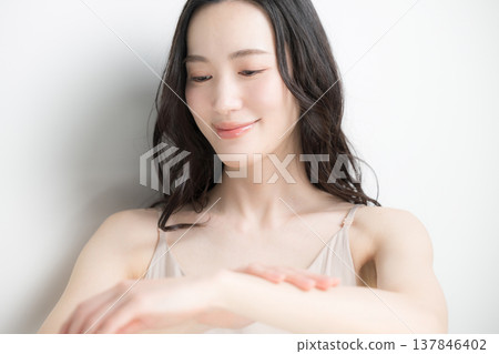 Beauty image of applying cream or sunscreen to the arm, white background. Beauty image of applying cream or sunscreen to the arm, white background. 137846402