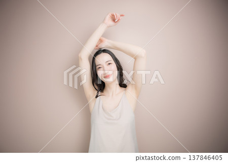 Image of a young woman's underarm beauty treatments and esthetics, including hair removal, against a pink beige background. Image of a young woman's underarm beauty treatments and esthetics, including hair removal, against a pink beige background. 137846405