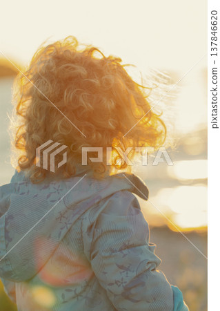 Curly Little Child Looking at Sunset Outdoors with Soft Backlight and copy space Curly Little Child Looking at Sunset Outdoors with Soft Backlight and copy space 137846620