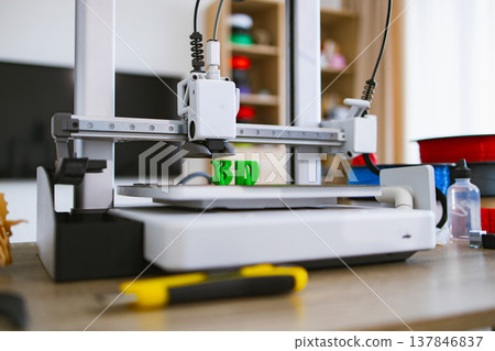 A modern 3D printer is actively creating the letters 3D in bright green plastic on its build plate A modern 3D printer is actively creating the letters 3D in bright green plastic on its build plate 137846837