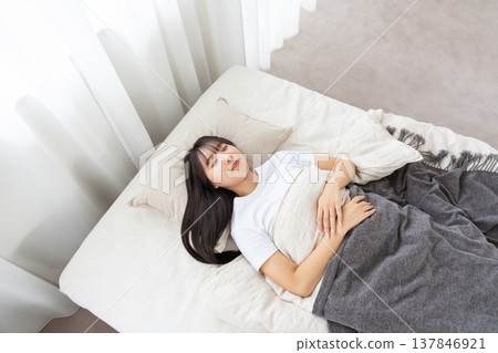 一個睡在床上的年輕女人 137846921