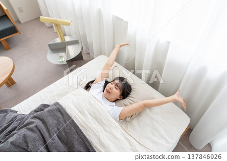 A woman stretching in bed A woman stretching in bed 137846926