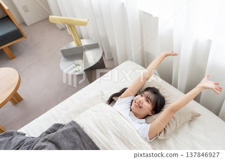 一個女人在床上伸展 一個女人在床上伸展 137846927