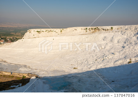 Visitors admire the white travertine terraces of Pamukkale in Turkey as the sun sets, highlighting the beauty and geological wonders of this unique location. Visitors admire the white travertine terraces of Pamukkale in Turkey as the sun sets, highlighting the beauty and geological wonders of this unique location. 137847016
