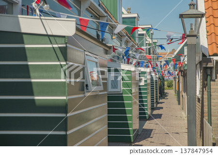 Traditional Green Wooden Sheds in Marken Netherlands with Festive Flags and Copy Space 137847954