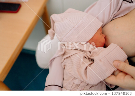 Mother feeding infant with breast milk at home. Concept of motherhood, newborn health and nurturing care. Mother feeding infant with breast milk at home. Concept of motherhood, newborn health and nurturing care. 137848163