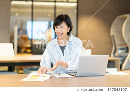 Middle-aged woman working in the office Middle-aged woman working in the office 137848197