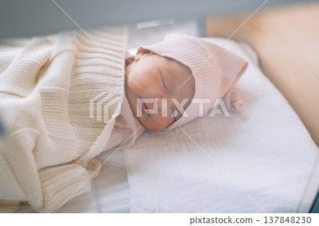 Infant resting comfortably in warm clothing during first days of life. Concept of newborn comfort and peaceful sleep in Klinikum  137848230