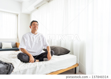 A middle-aged man relaxing in bed A middle-aged man relaxing in bed 137848314