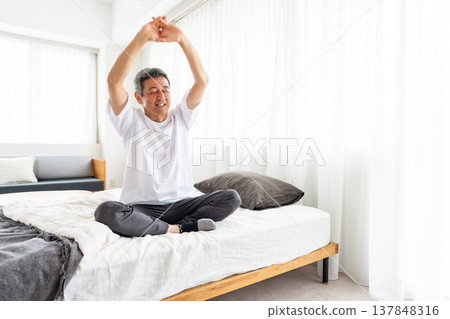 Middle-aged man stretching in bed Middle-aged man stretching in bed 137848316