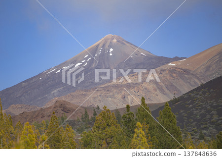 Iconic peak of Mount Teide volcano with snow and pine forest with copy space in sky Iconic peak of Mount Teide volcano with snow and pine forest with copy space in sky 137848636