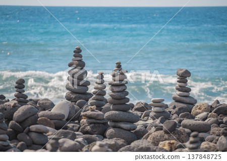 Zen stone towers balanced on rocky shore with vast copy space in blue ocean Zen stone towers balanced on rocky shore with vast copy space in blue ocean 137848725