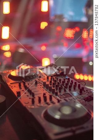 Professional DJ Deck with Red Stage Lighting and Large Copy Space on Blurred Bokeh Background Professional DJ Deck with Red Stage Lighting and Large Copy Space on Blurred Bokeh Background 137848782