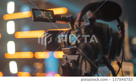 Professional Video Camera on Tripod Filming Event with Bright Bokeh Lights and Copy Space Professional Video Camera on Tripod Filming Event with Bright Bokeh Lights and Copy Space 137848783
