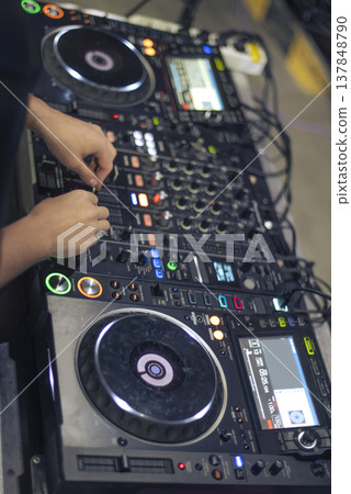 High-Angle View of Professional DJ Hands Mixing Music on Digital Audio Console 137848790