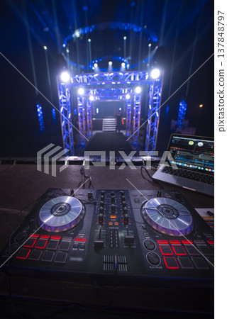 Professional DJ Controller on Stage with Dynamic Blue Lighting and Copy Space Professional DJ Controller on Stage with Dynamic Blue Lighting and Copy Space 137848797