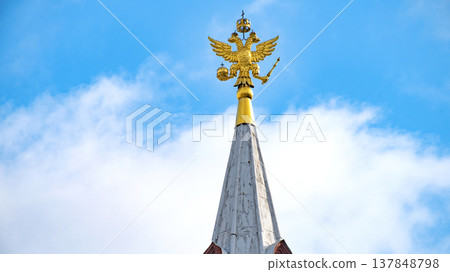 Golden Russian Double-Headed Eagle on Spire with Blue Sky Copy Space Golden Russian Double-Headed Eagle on Spire with Blue Sky Copy Space 137848798