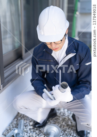 一名鷹架工人正在檢查鷹架材料(未顯示臉部)。 一名鷹架工人正在檢查鷹架材料(未顯示臉部)。 137849018