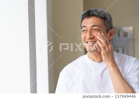 Senior man smiling and holding his hand on his cheek Senior man smiling and holding his hand on his cheek 137849446