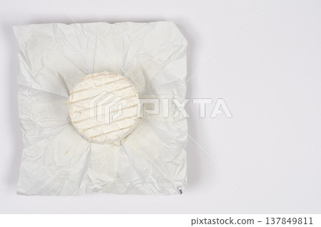 Small round blue cheese in opened paper wrapper Small round blue cheese in opened paper wrapper 137849811