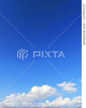 A vertical background image of clouds floating in a blue sky. A vertical background image of clouds floating in a blue sky. 137850157