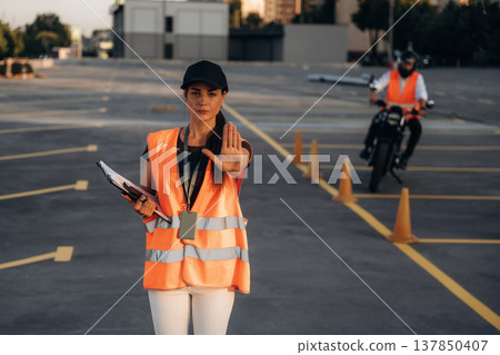 Stop hand gesture. Motorcycle driving license exam. Man and woman are in uniforms 137850407