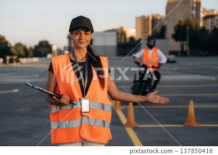 Motorcycle driving license exam. Man and woman are in uniforms Motorcycle driving license exam. Man and woman are in uniforms 137850416