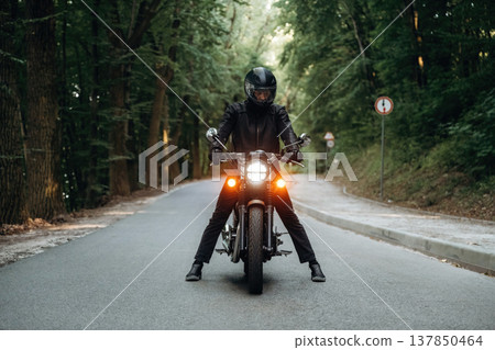 In leather clothes. Man is on motorcycle is on the road In leather clothes. Man is on motorcycle is on the road 137850464